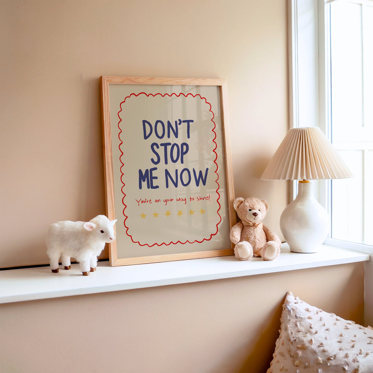 Dont stop me now star lettering nursery print in an oak frame on a window ledge with a toy lamb and teddy