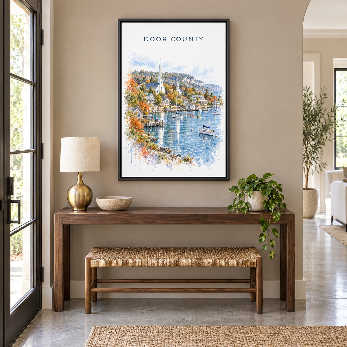 Door County watercolor print as a black floater canvas above a walnut console and woven bench in an entryway