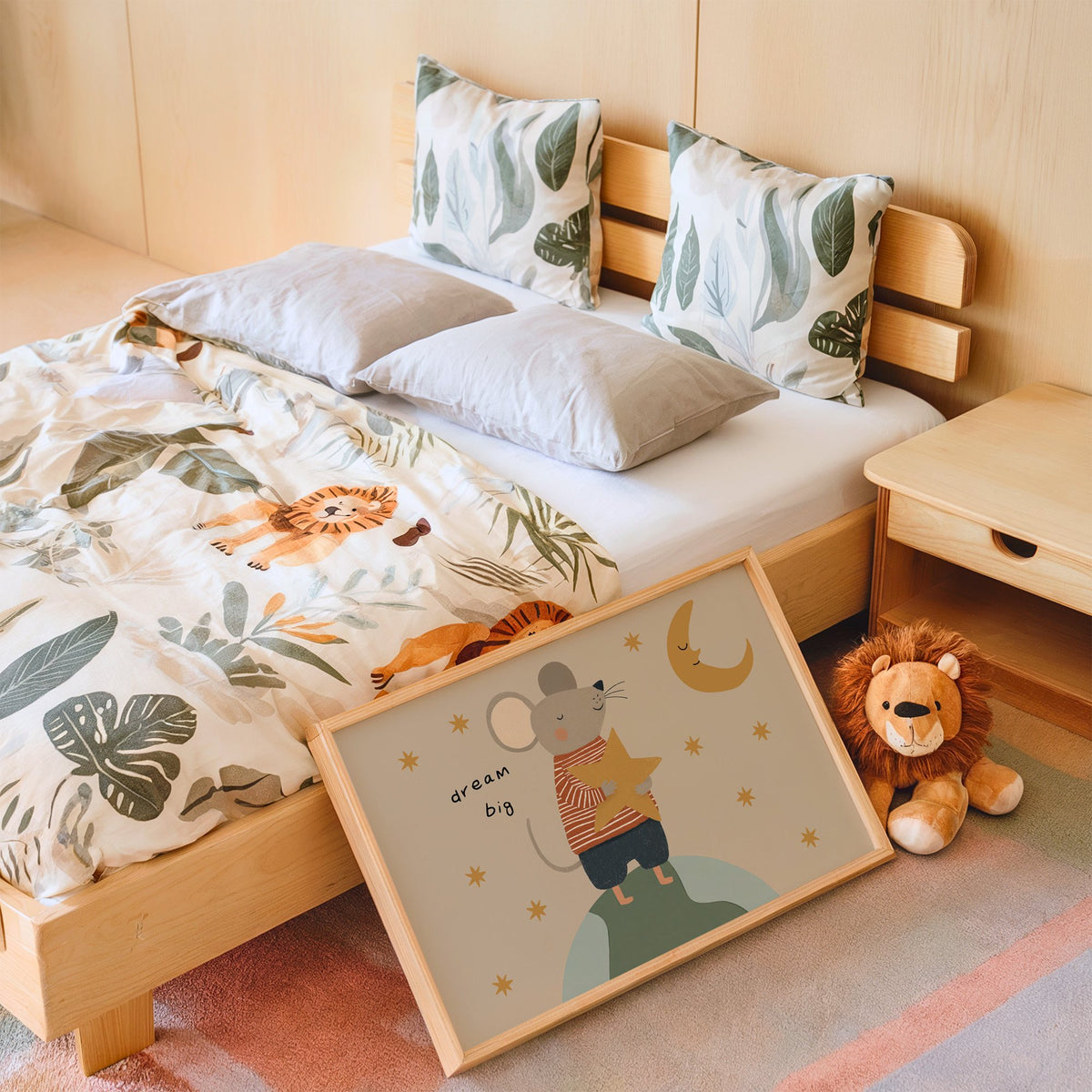 Landscape dream big mouse hugging star nursery print in an oak frame leaning on a kids bed by a lion plush