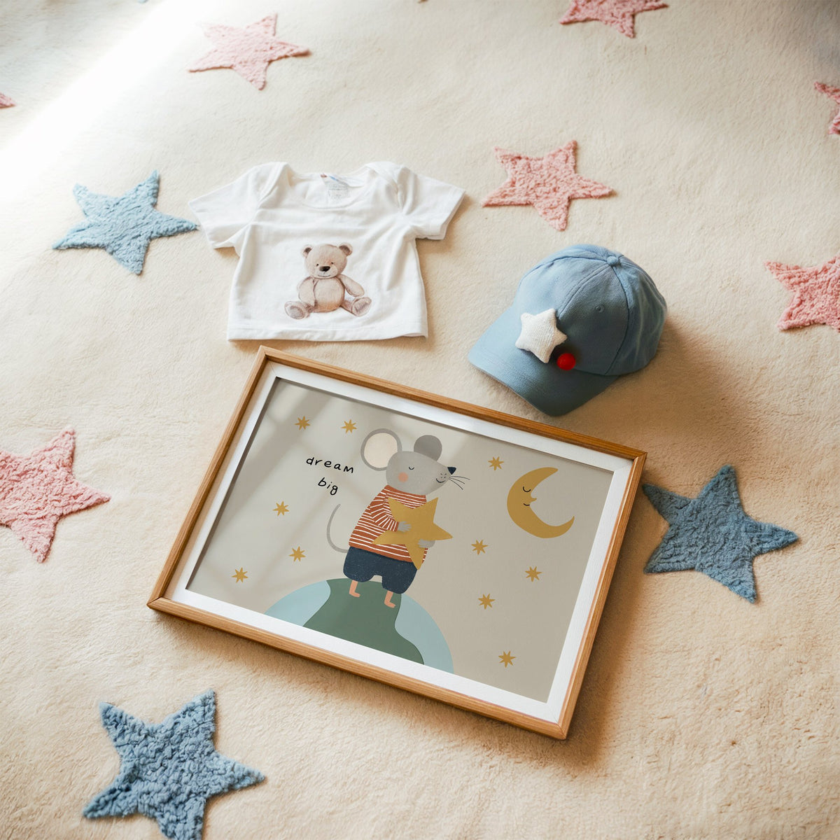 Landscape dream big mouse hugging star nursery print in a matted oak frame on a star rug with a baby tee