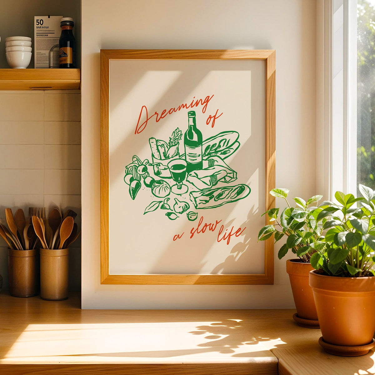 Dreaming of a Slow Life print in a light pine frame beside a jar of wooden spoons