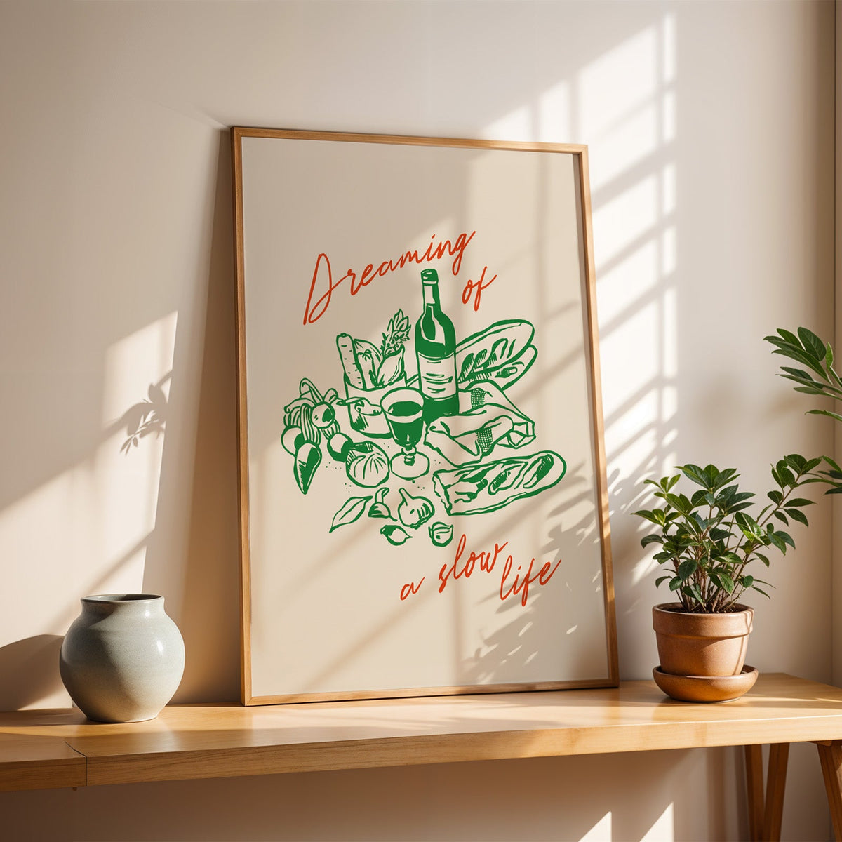 Dreaming of a Slow Life print in a slim oak frame on a console with a grey-blue vase