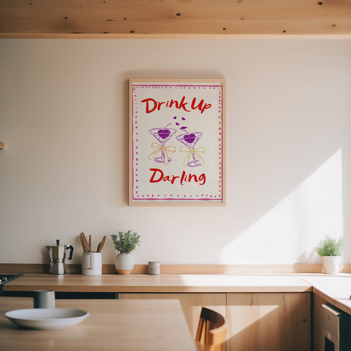Drink Up Darling print in an oak frame above a wood counter with a moka pot and herbs