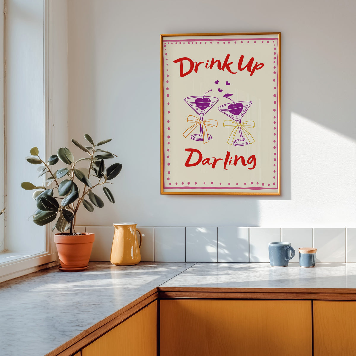 Drink Up Darling print in a gold frame above a marble counter with a yellow ceramic jug