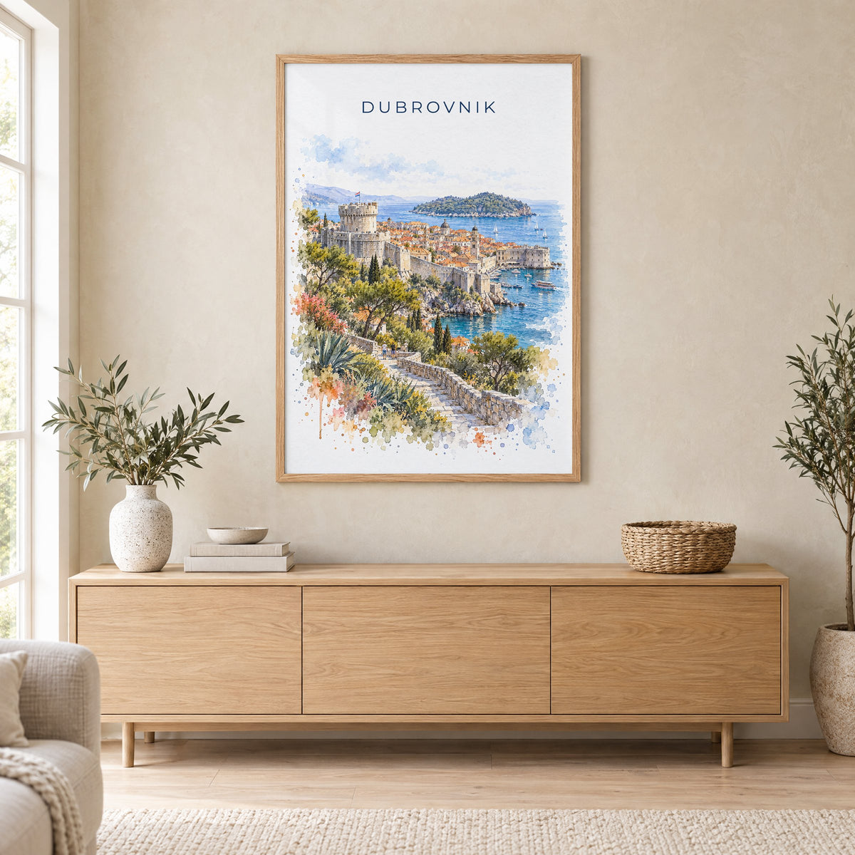 Dubrovnik watercolor print in an oak frame above a light wood sideboard in a Scandinavian living room