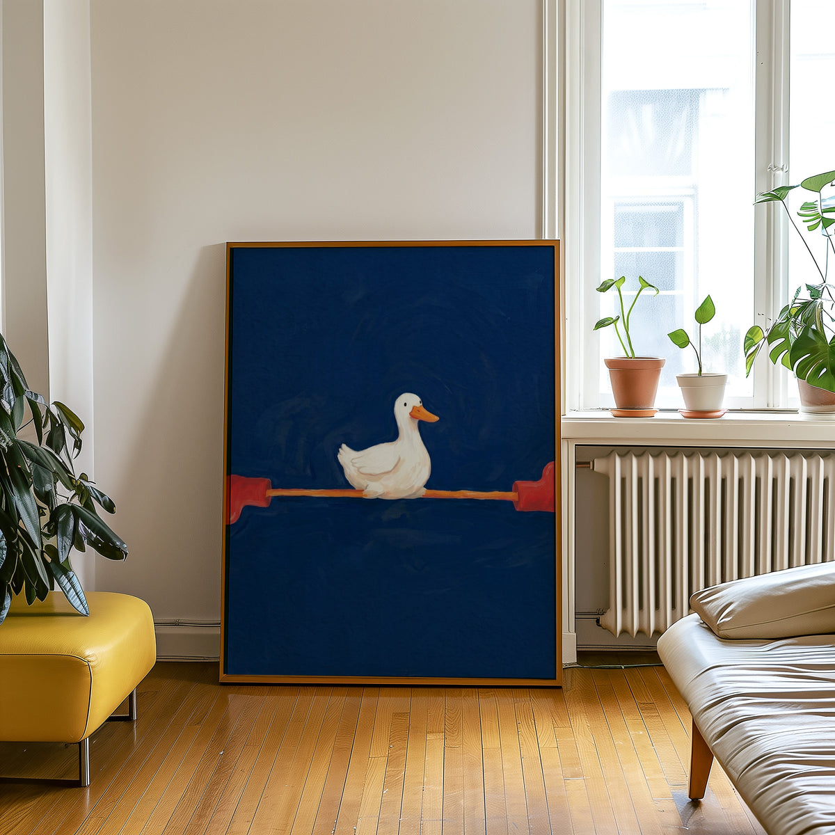 Yoga duck print in an oak frame leaning beside a yellow leather bench