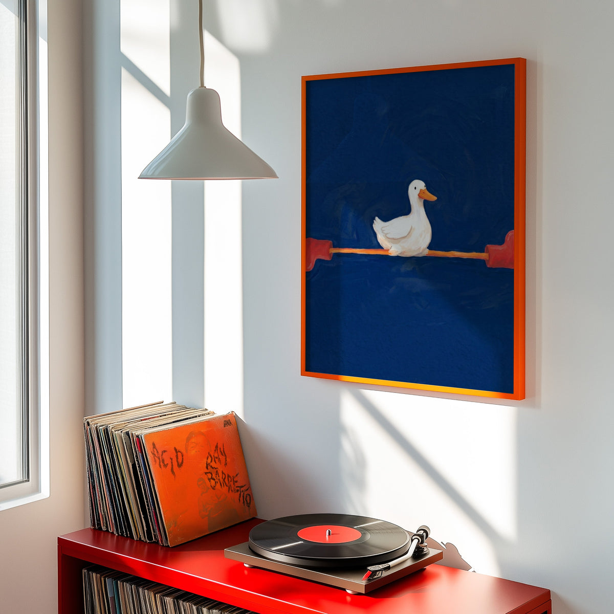 Navy duck wall art print shown in an orange frame above a red record cabinet and turntable