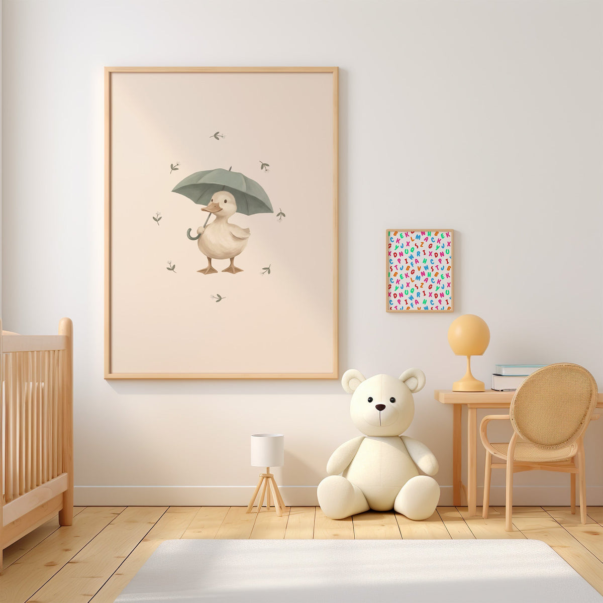 Cream duck holding a sage umbrella nursery print in an oak frame above a wooden crib beside a cream teddy bear