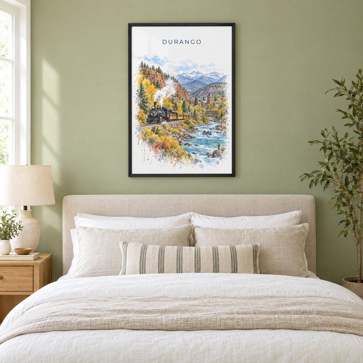 Durango, Colorado watercolor print in a black frame above an upholstered headboard in a sage green bedroom