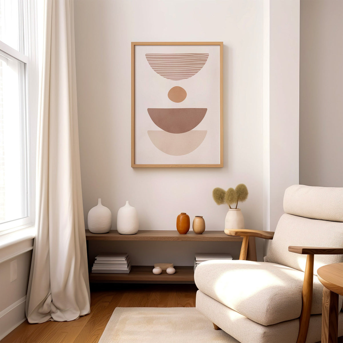 Dusty rose striped bowl shapes boho print in an oak frame above a wood console shelf by a cream boucle armchair