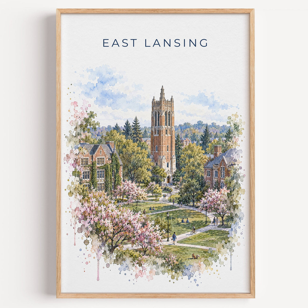 East Lansing watercolor print in a light oak frame on a plain white wall