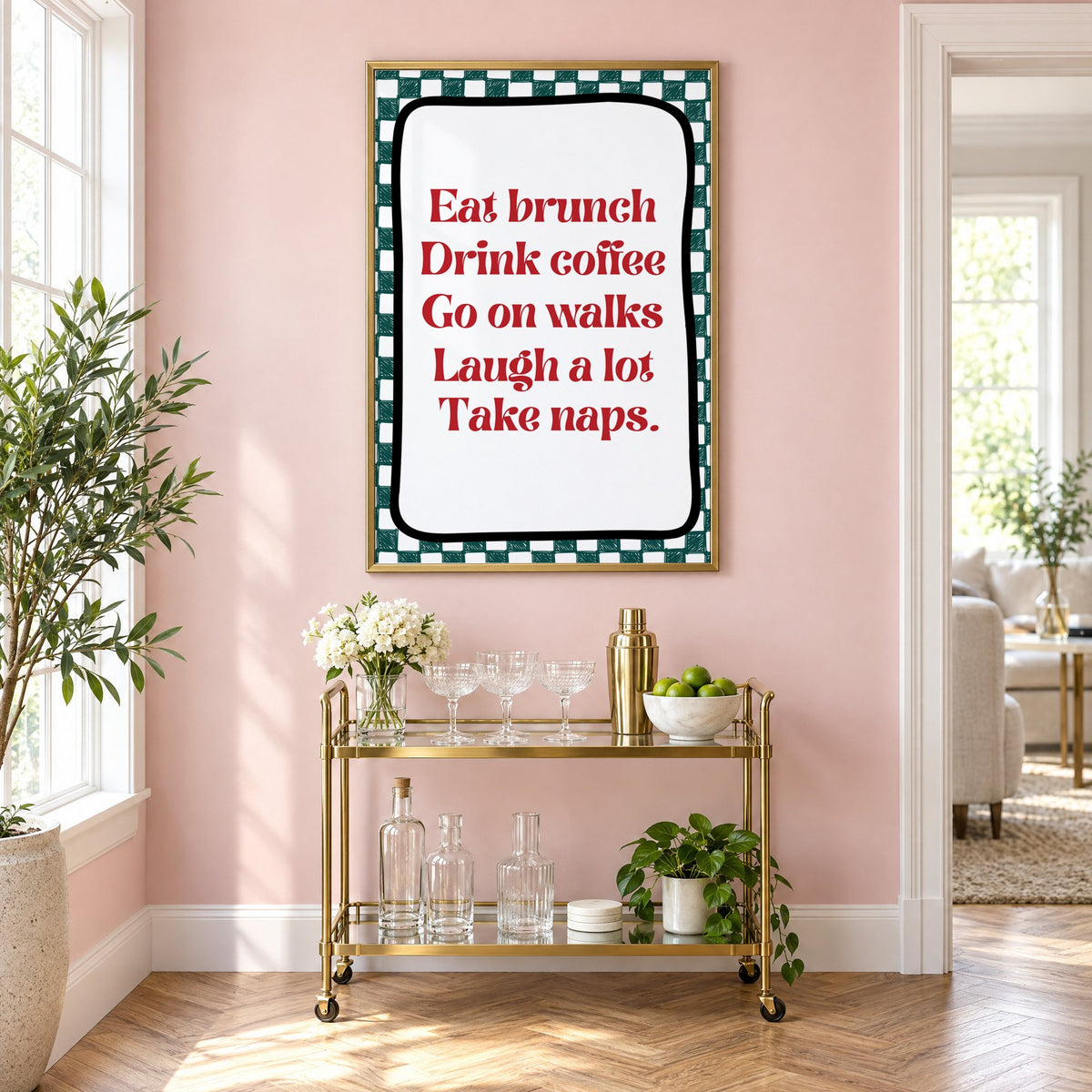 Eat brunch drink coffee check print in a brass frame above a gold bar cart on a blush pink wall