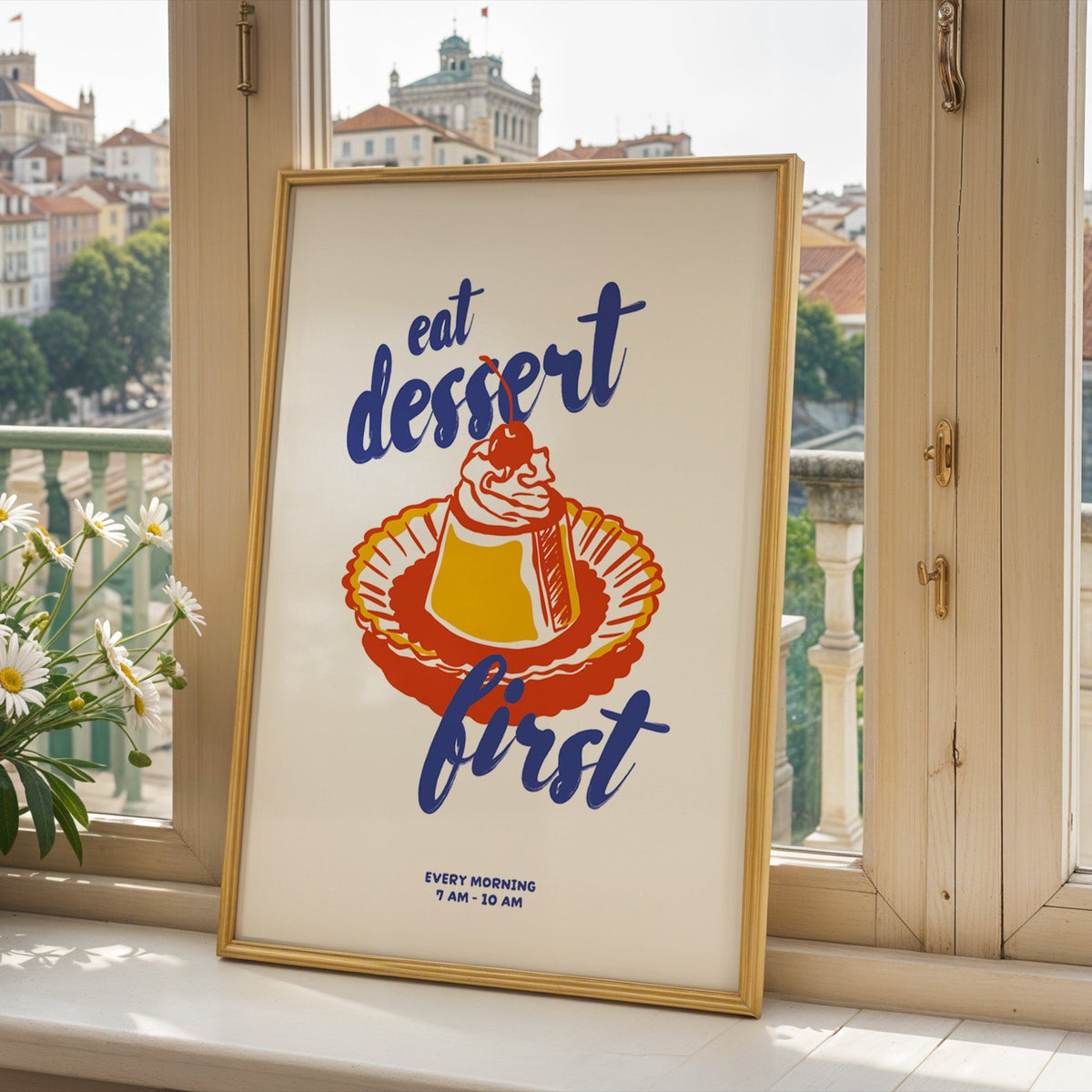 Bakery flan print in a gold frame on a window sill overlooking a hillside town