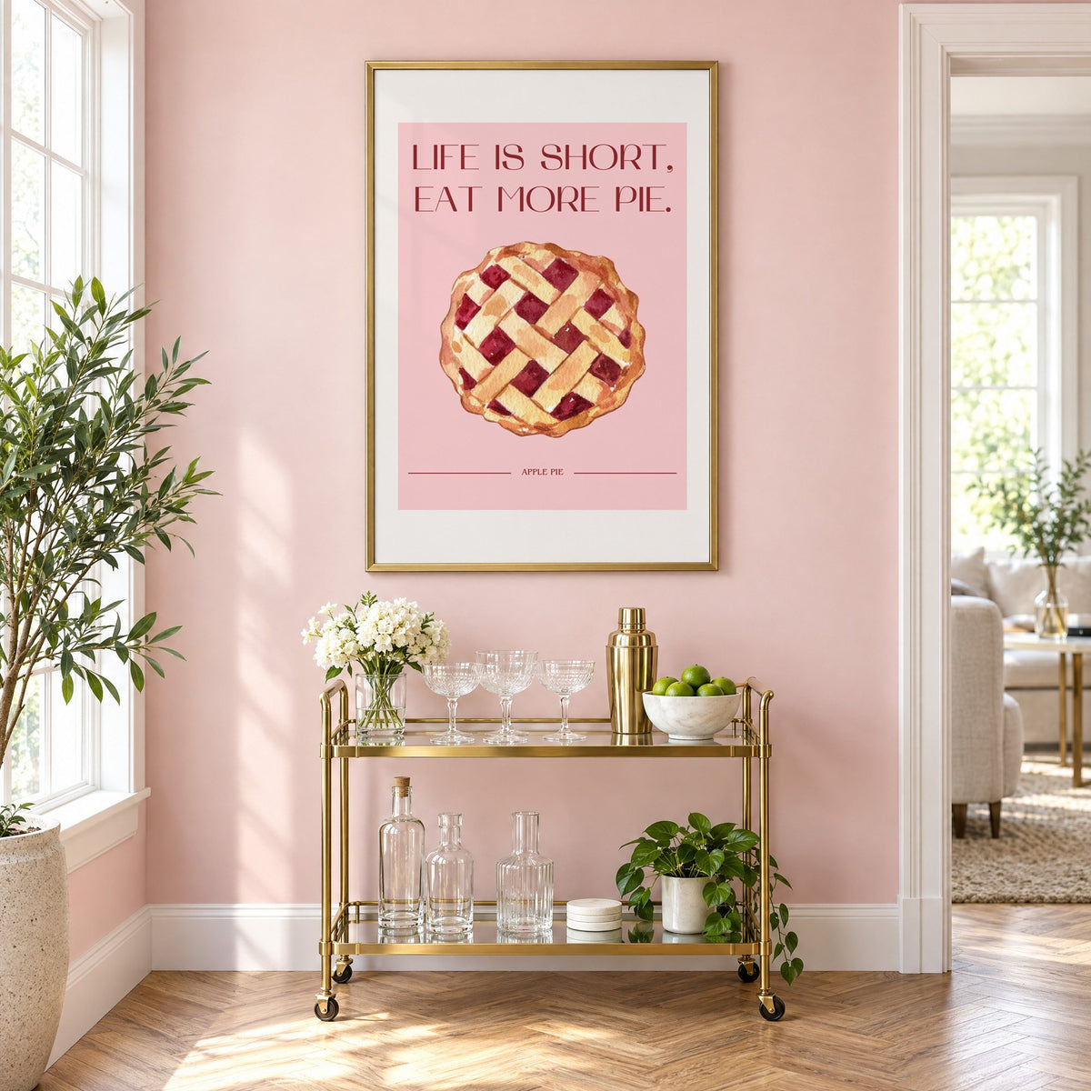 Eat More Pie watercolor print in a brass frame above a gold bar cart on a blush pink wall