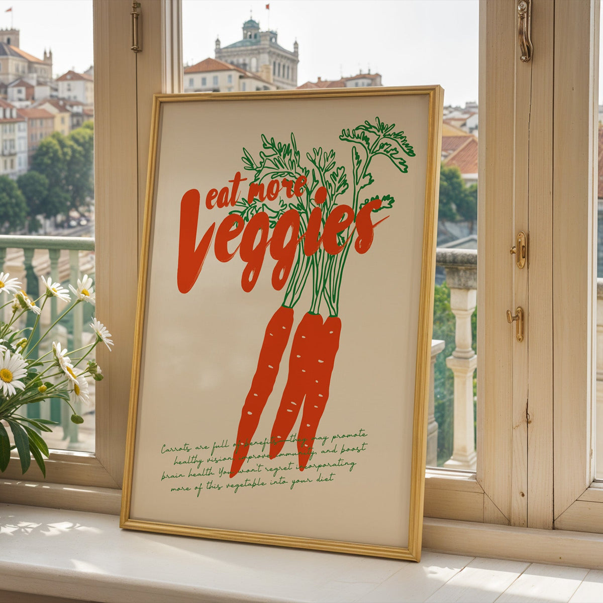 Carrots print in a gold frame on a window sill overlooking a hillside town