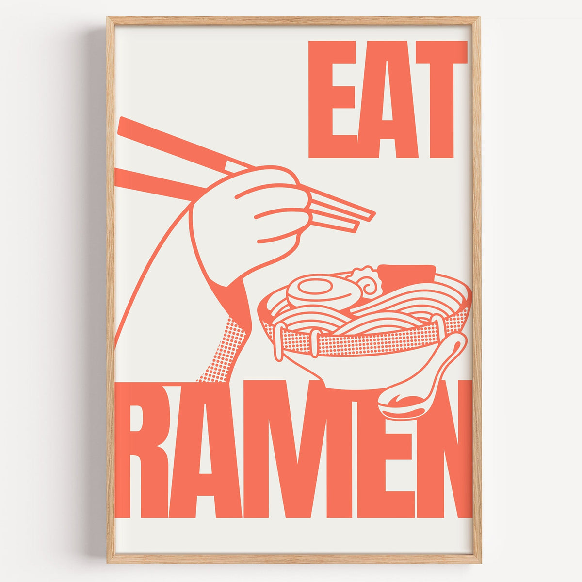 Eat Ramen coral line print in a light oak frame on a plain white wall