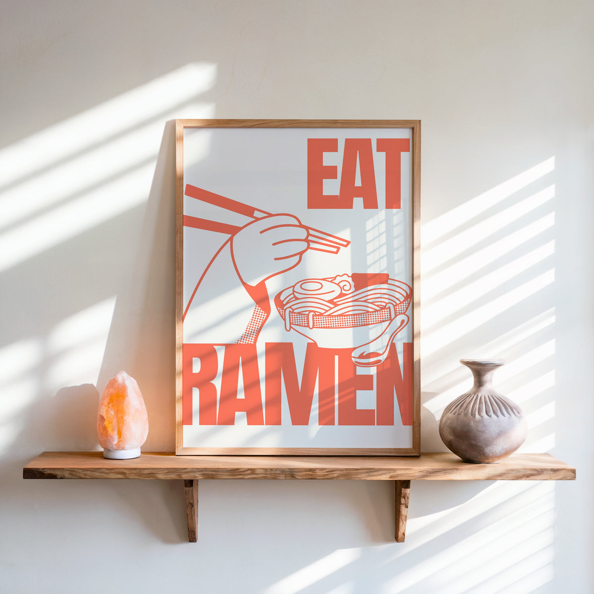 Eat Ramen print in an oak frame on a live-edge shelf beside a salt lamp