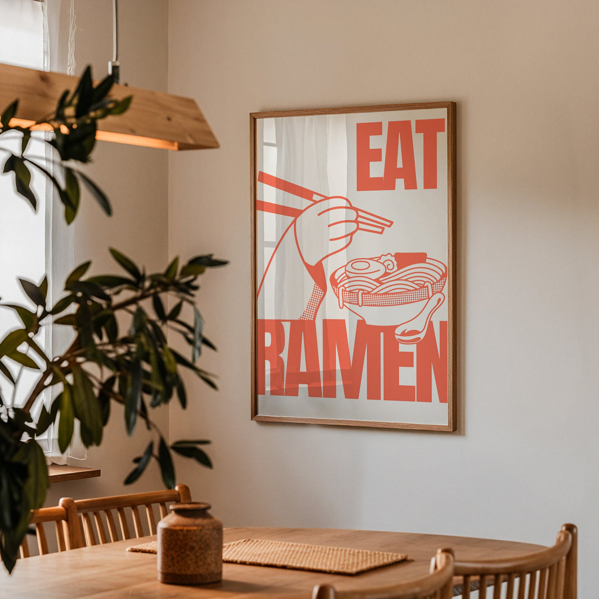 Eat Ramen print in a walnut frame above a dining table with olive branches