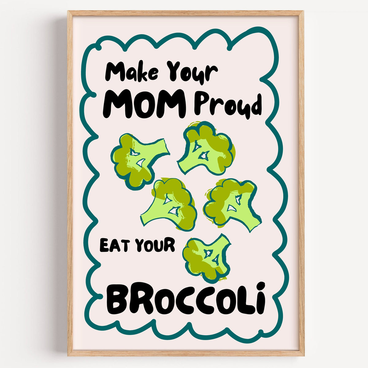 Eat Your Broccoli pink kitchen print in a light oak frame on a plain white wall