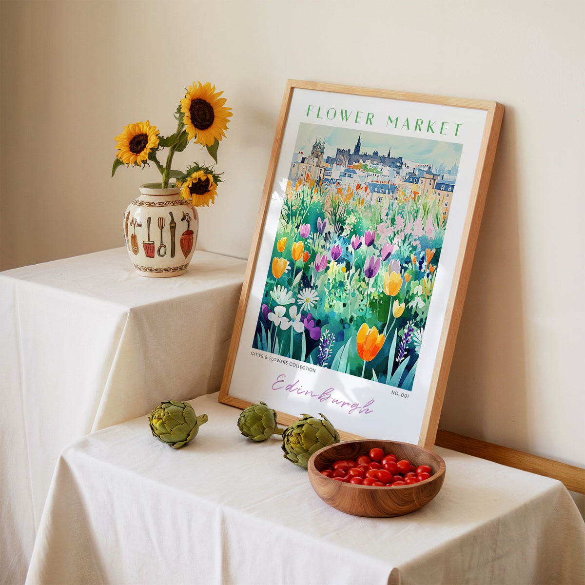 Edinburgh flower market print in an oak frame leaning on a linen-draped table beside a vase of sunflowers