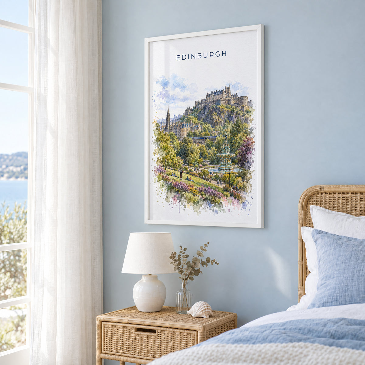 Edinburgh watercolor print in a white frame on a pale blue wall beside a rattan bed in a coastal bedroom
