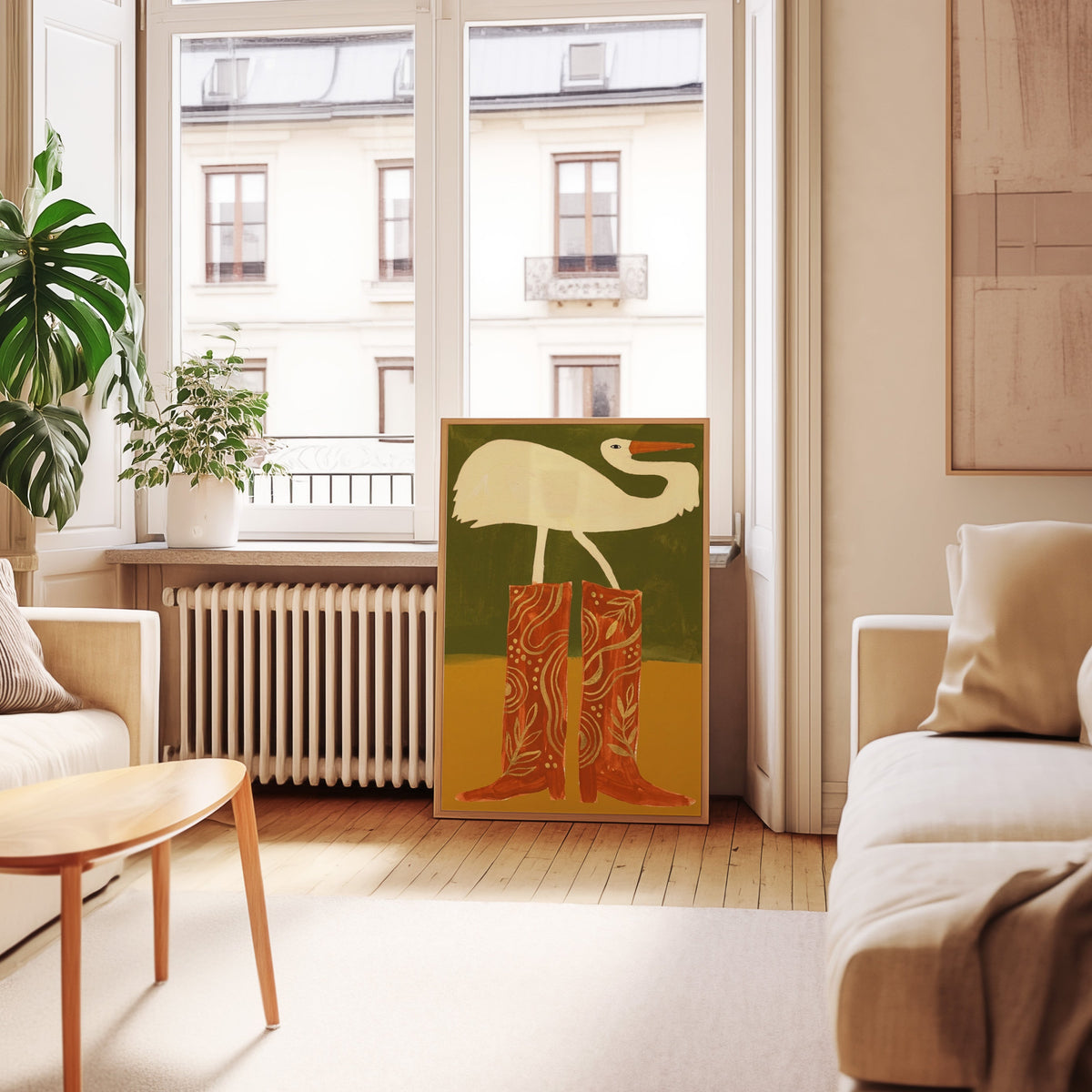White egret western print in an oak frame leaning below tall French windows