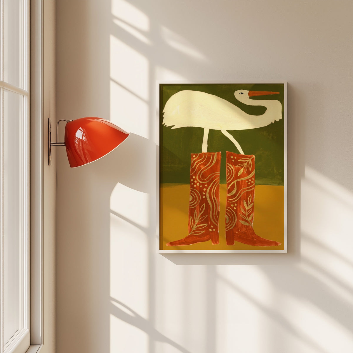 Egret in cowboy boots print in a white frame beside a red wall sconce