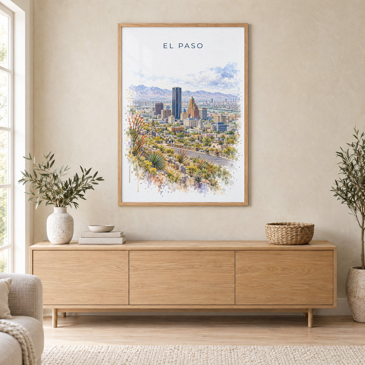 El Paso watercolor print in an oak frame above a light wood sideboard in a Scandinavian living room