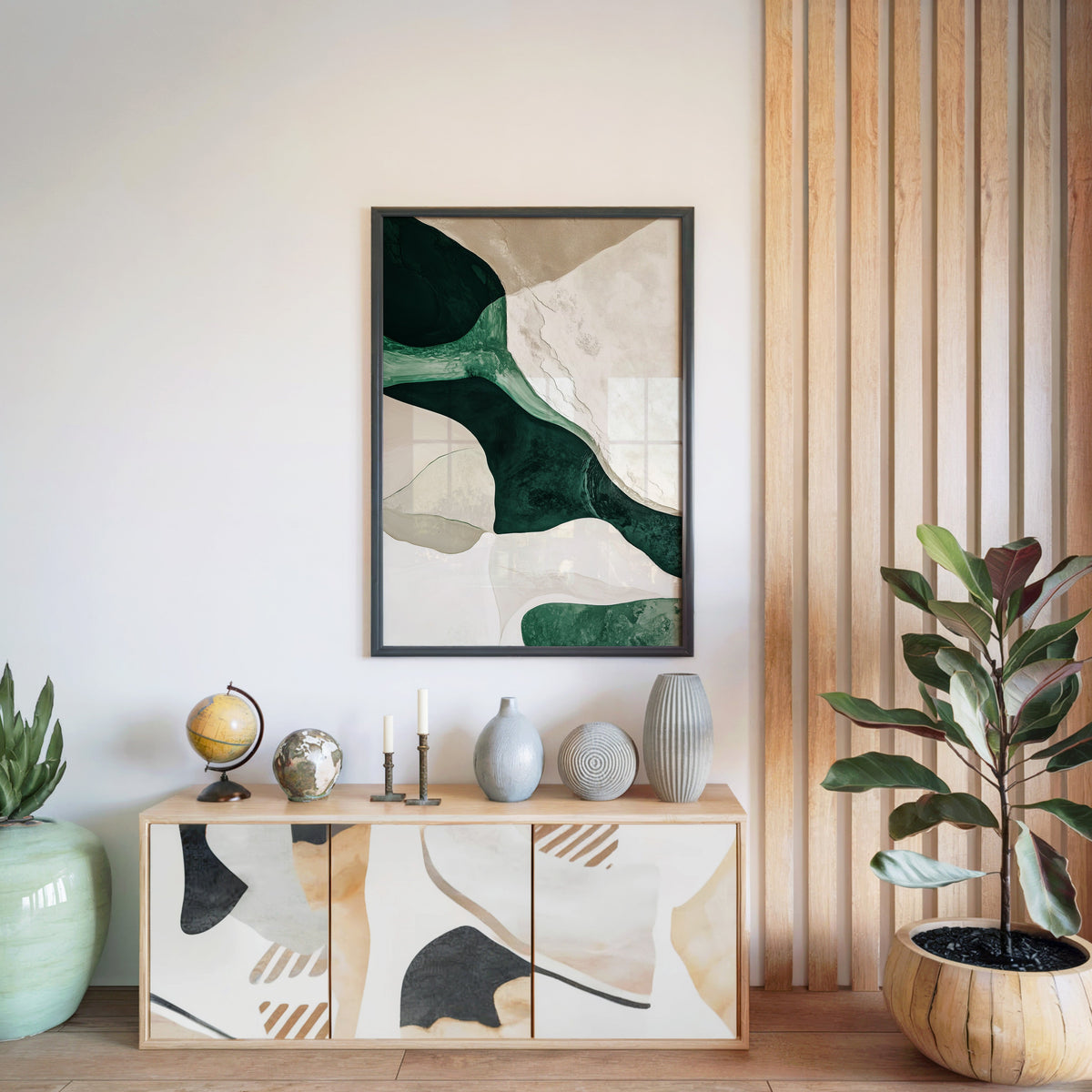Emerald and cream organic shapes abstract print in a black frame above a light wood sideboard by a wood slat wall