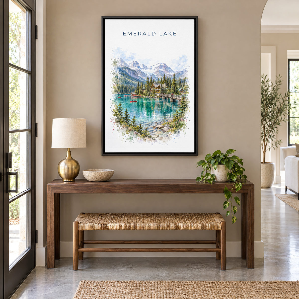 Emerald Lake, BC watercolor print as a black floater canvas above a walnut console and woven bench in an entryway