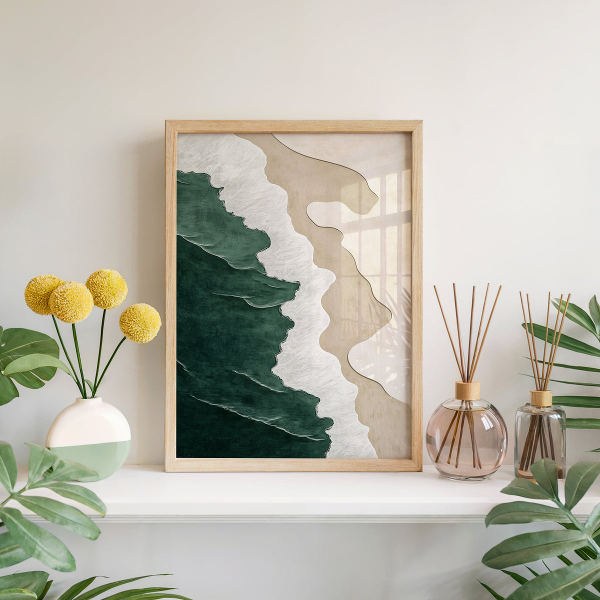 Emerald, white and sand shoreline abstract print in a light oak frame leaning on a white mantel with yellow flowers