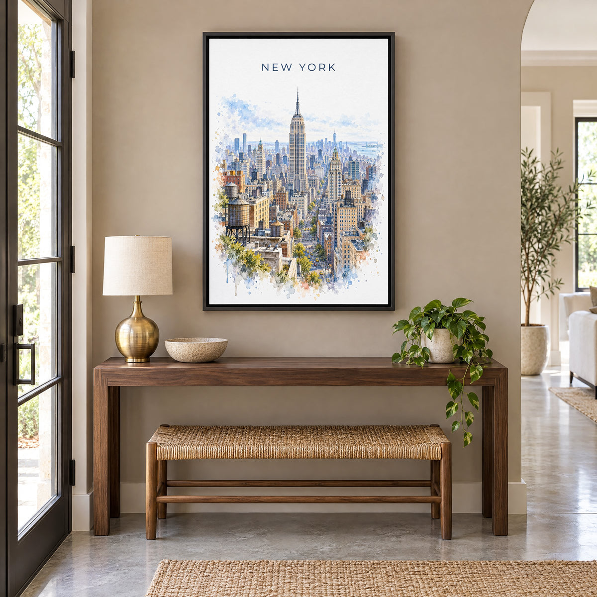 Empire State Building watercolor print as a black floater canvas above a walnut console and woven bench in an entryway