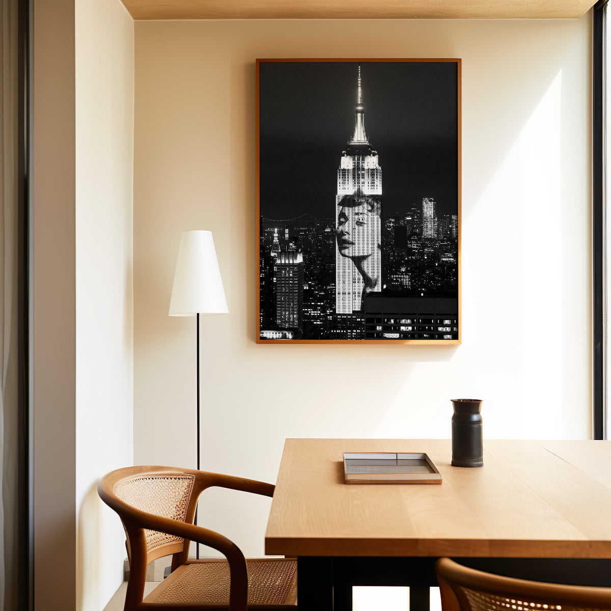 Empire State Building at night with projected face print in an oak frame above a dining table and cane chair