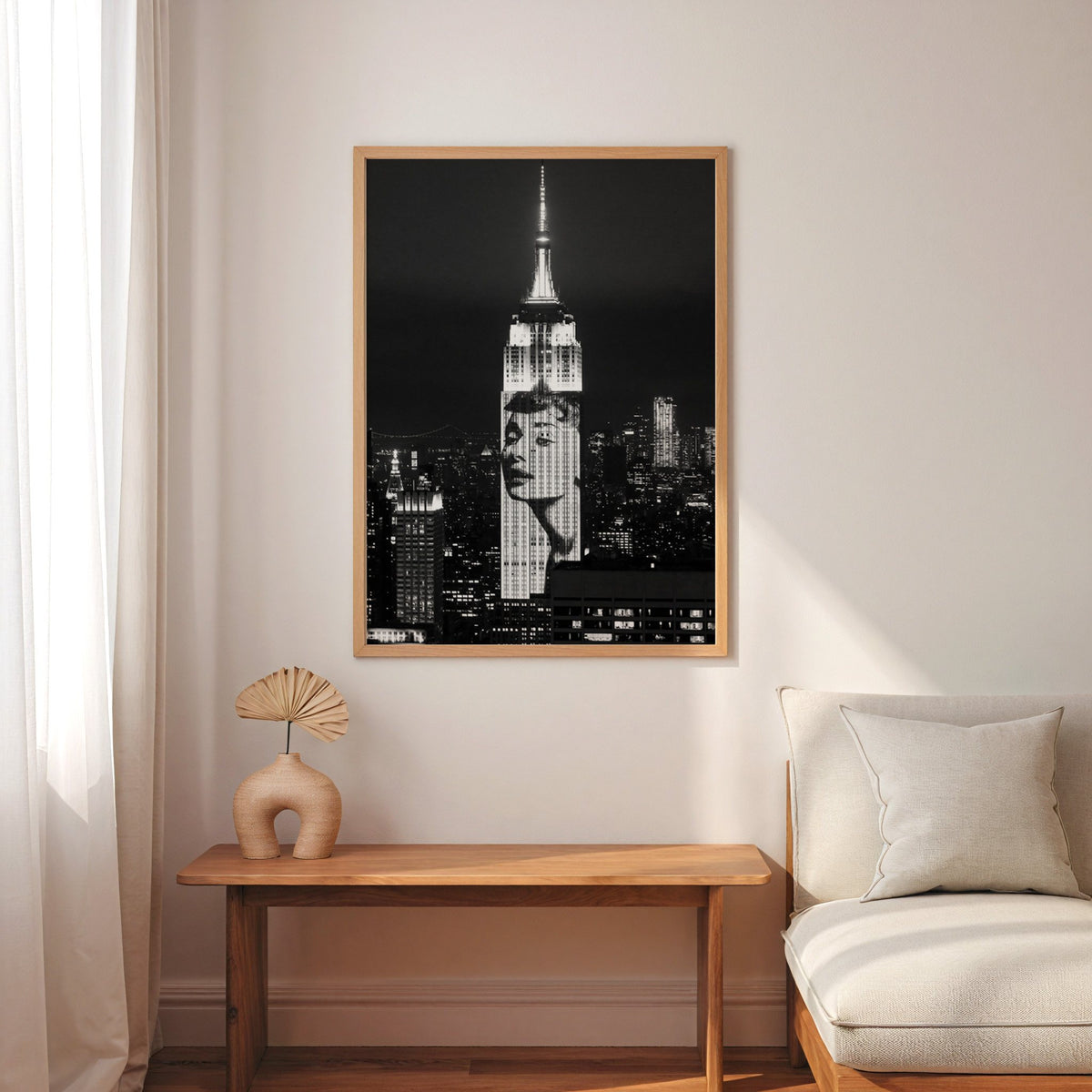 Empire State Building at night with projected face print in an oak frame above a narrow console with an arched vase
