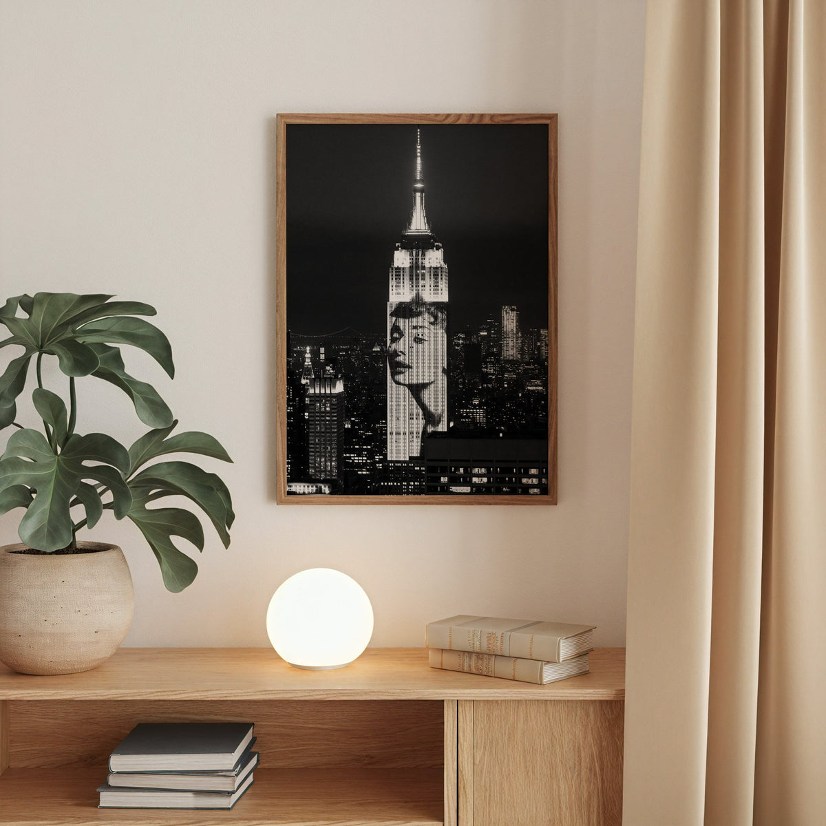 Empire State Building at night with projected face print in a walnut frame above an oak cabinet with a glowing globe lamp
