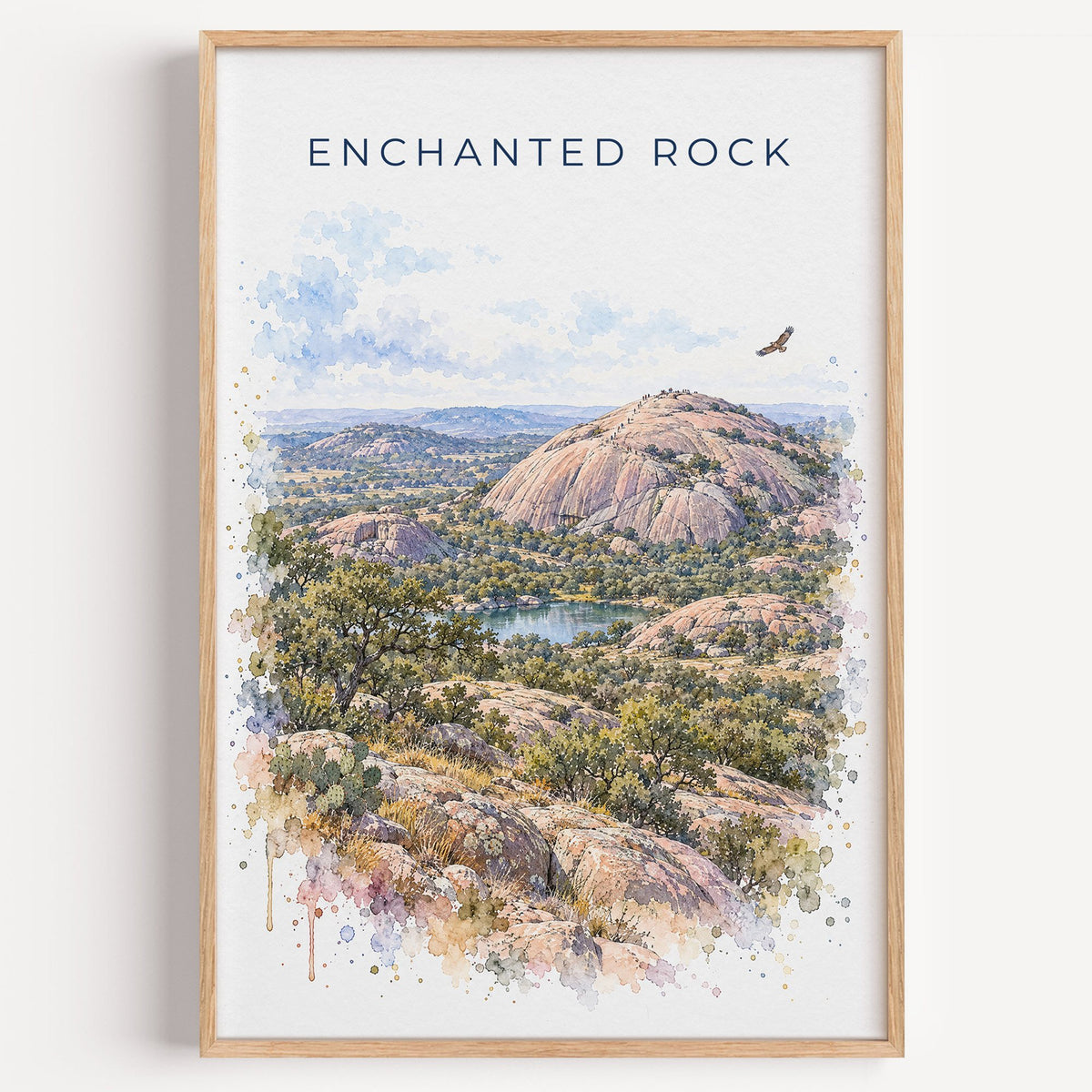 Enchanted Rock watercolor print in a light oak frame on a plain white wall