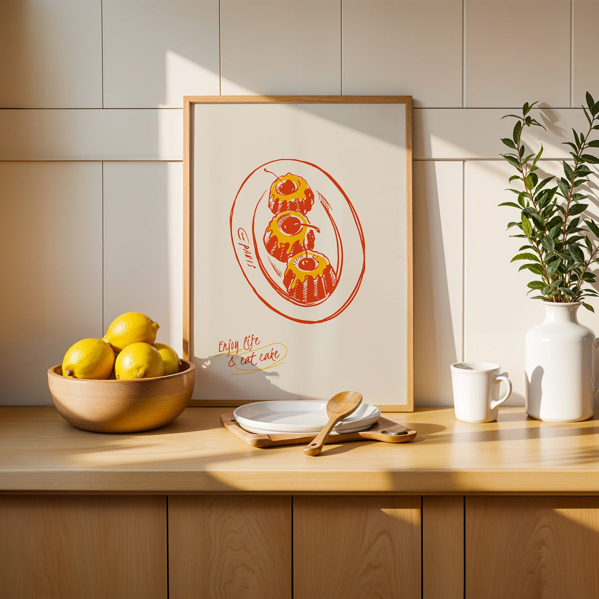 Enjoy Life and Eat Cake print in a slim oak frame beside a wooden bowl of lemons