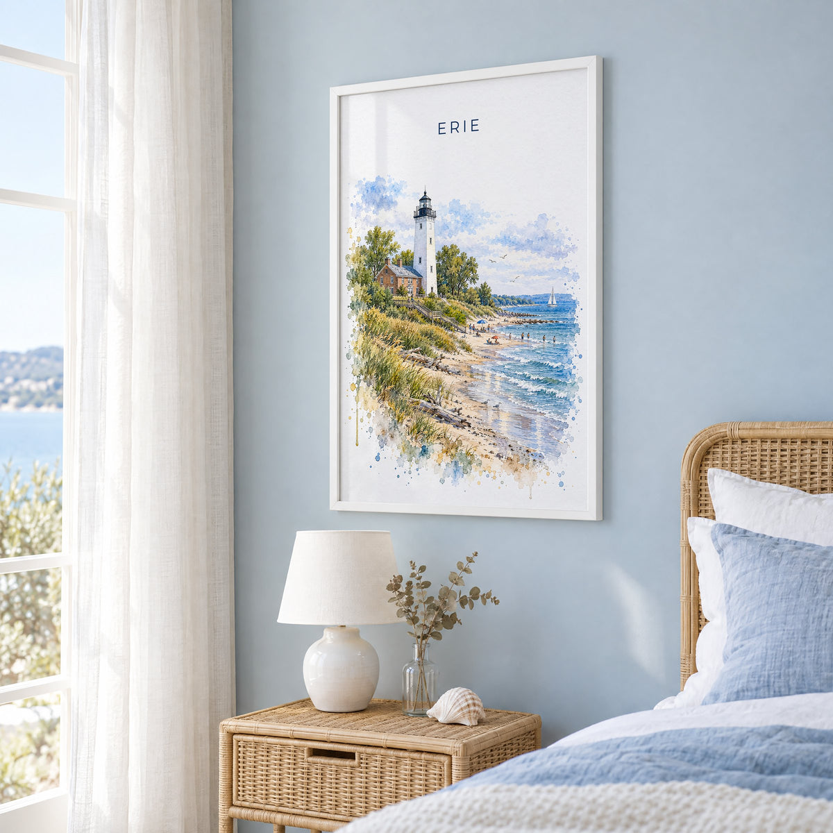 Erie, Pennsylvania watercolor print in a white frame on a pale blue wall beside a rattan bed in a coastal bedroom