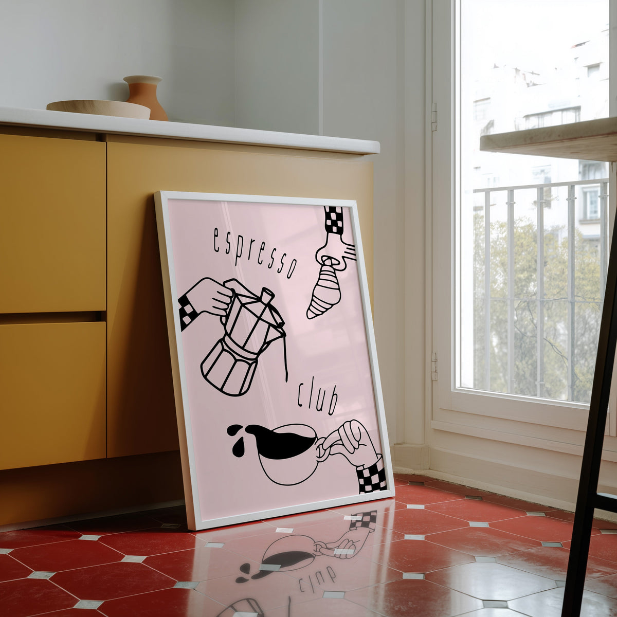 Espresso Club print in a white frame against yellow cabinets on a red tiled floor