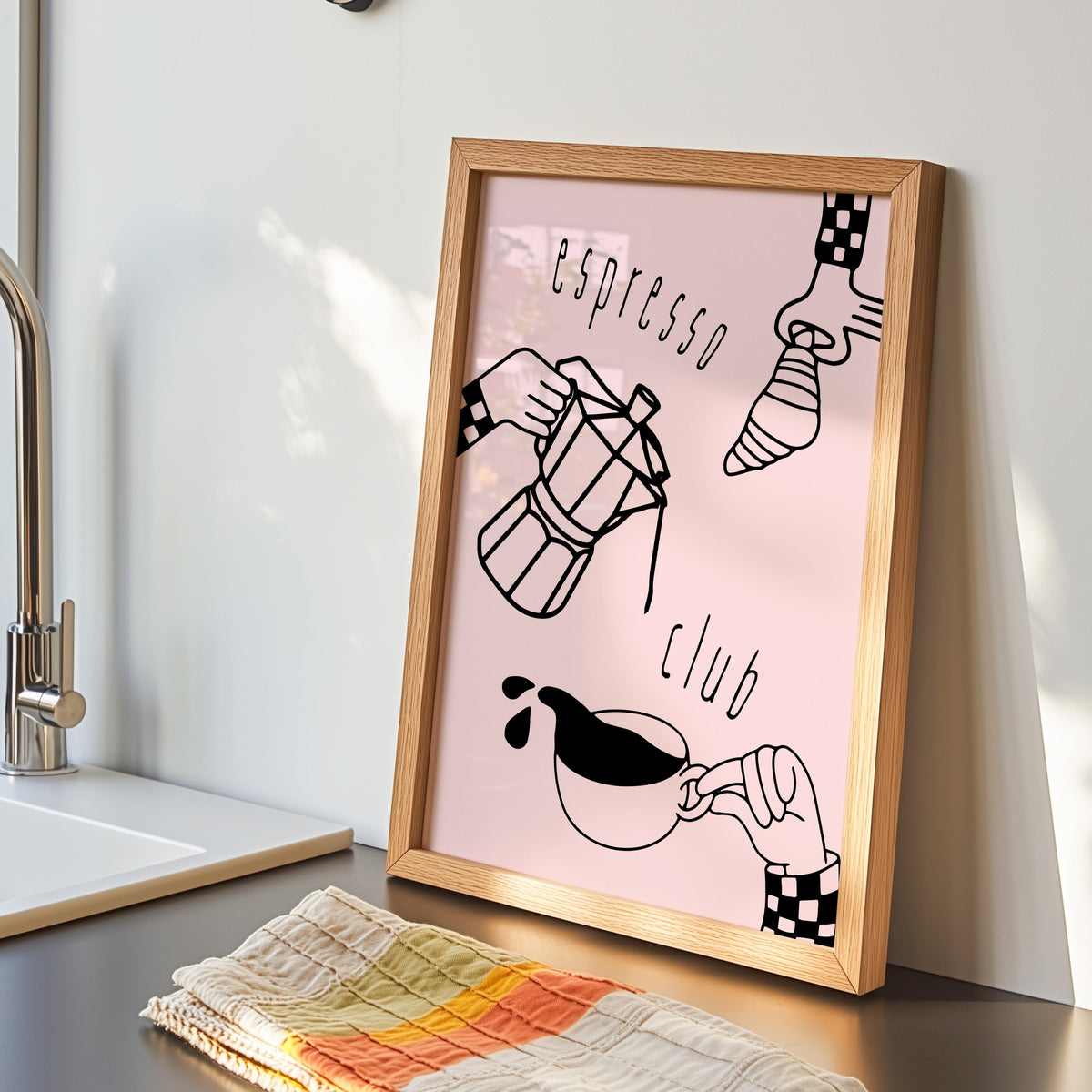 Espresso Club print in an oak frame by the kitchen sink beside a striped tea towel