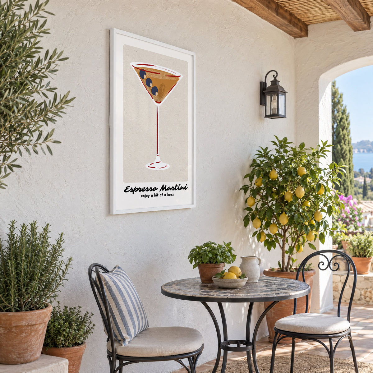 Espresso Martini cocktail glass print in a white frame on a sunny patio wall beside a potted lemon tree