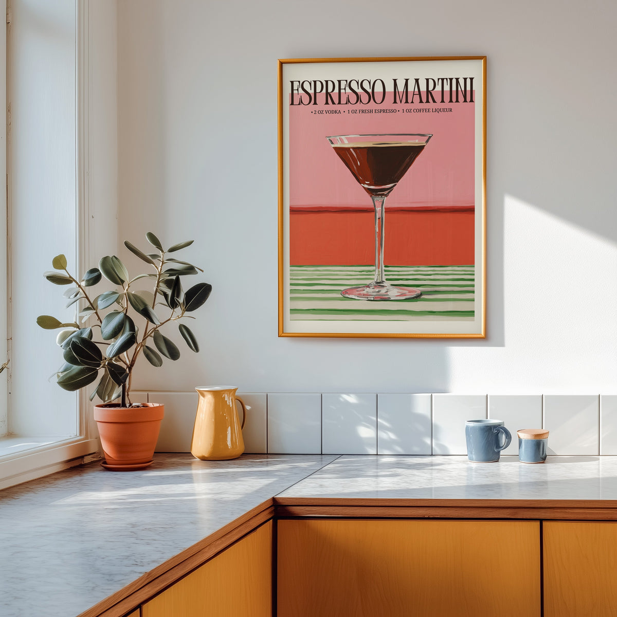 Espresso martini recipe print shown in a gold frame above a marble counter in a tan kitchen