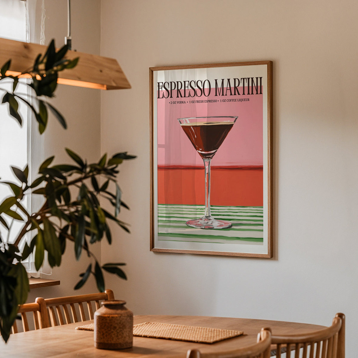 Espresso martini recipe print in a walnut frame above a dining table with olive branches
