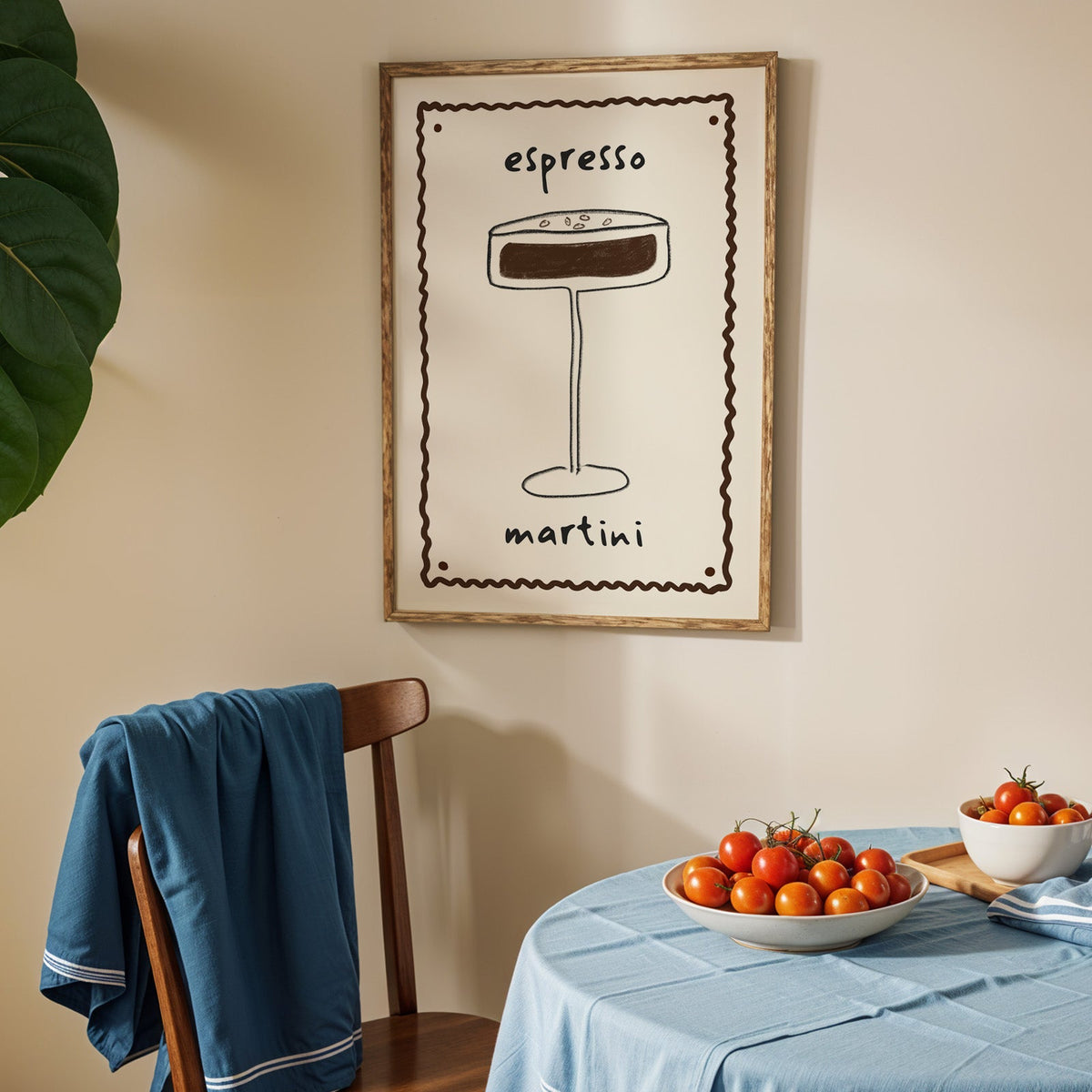 Espresso martini pencil line print in an oak frame above a blue linen table with ripe tomatoes