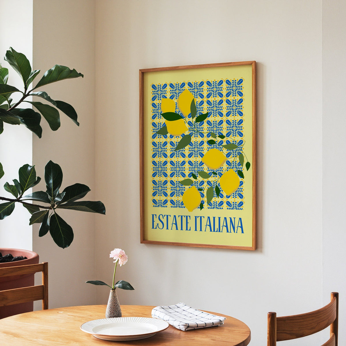 Estate Italiana lemon print in a walnut frame above a round table beside a fiddle-leaf fig