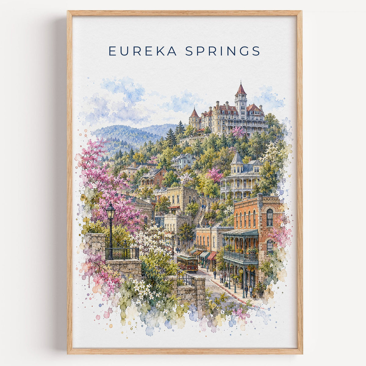 Eureka Springs watercolor print in a light oak frame on a plain white wall