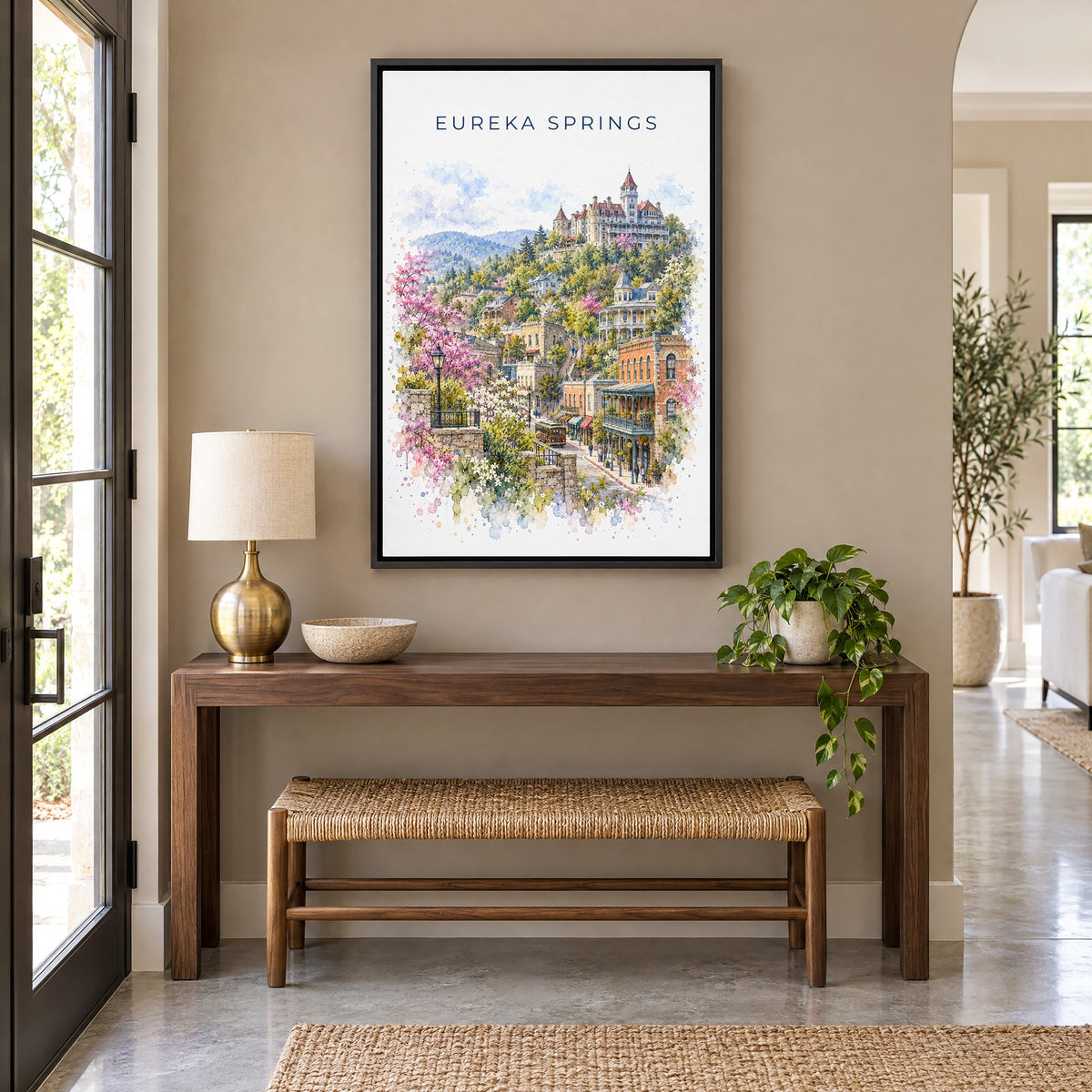 Eureka Springs watercolor print as a black floater canvas above a walnut console and woven bench in an entryway