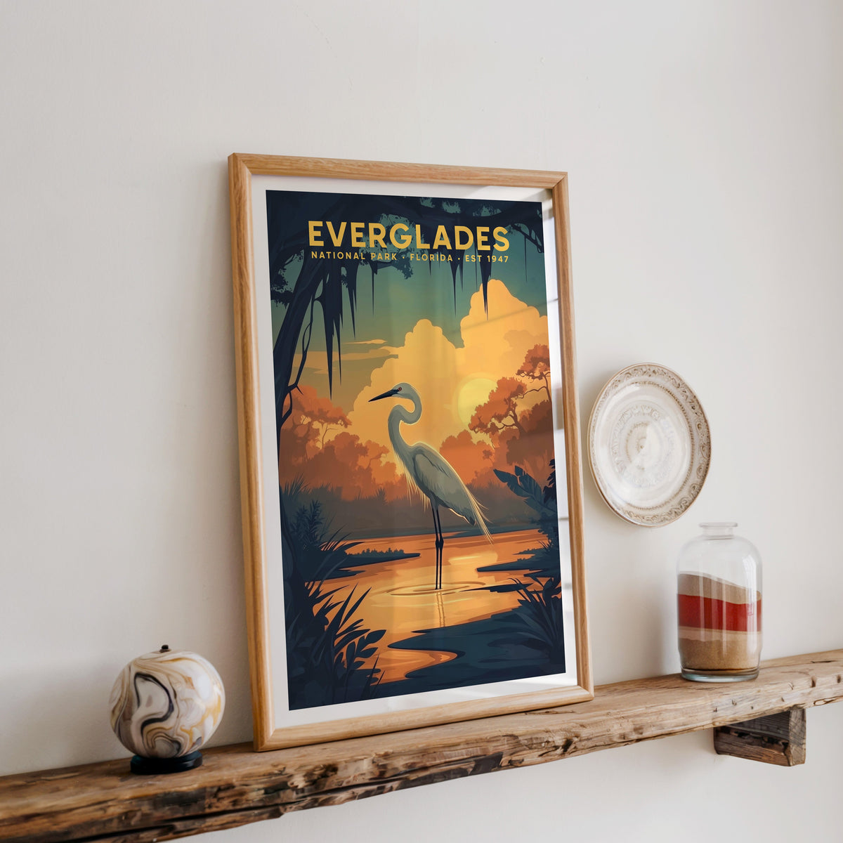Everglades National Park print in an oak frame on a rustic wood shelf with ceramics