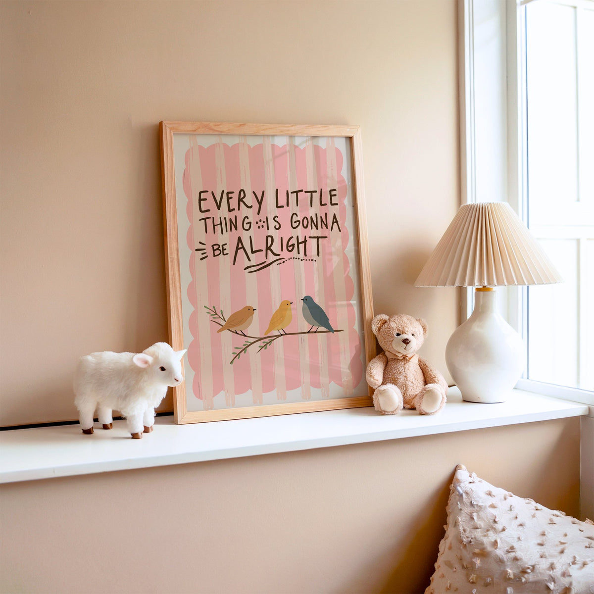 Every little thing birds quote nursery print in an oak frame on a window ledge with a toy lamb and teddy