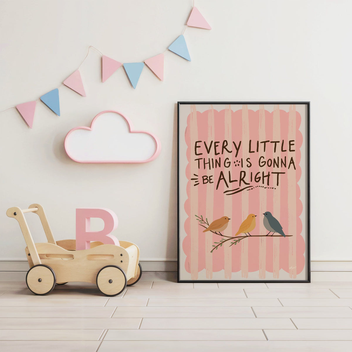 Every little thing birds quote nursery print in a black frame under pastel bunting by a wooden baby walker